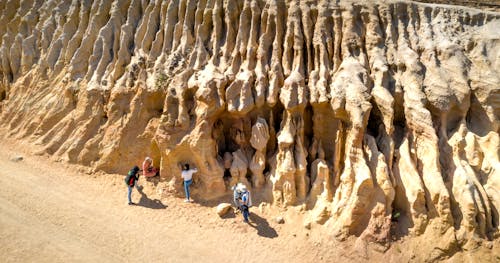 People Exploring Ancient Rocks in Desert