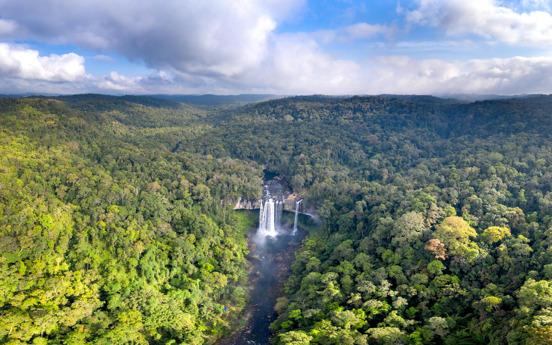 Stunning aerial photograph capturing a grand waterfall within the dense Kon Chu Rang nature reserve in Vietnam.