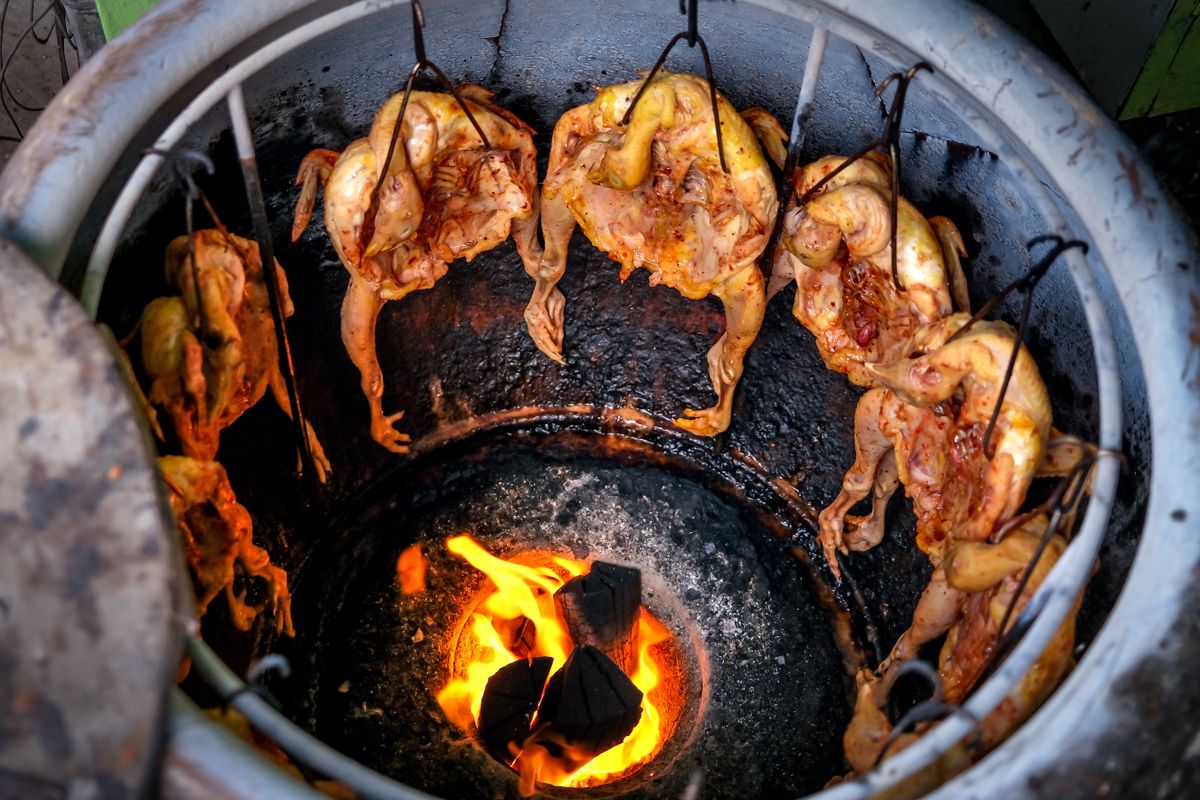 Fuego abierto preparando pollo a la leña