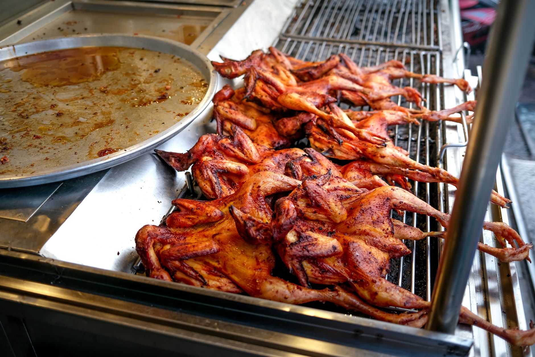 Grilled chicken thigh pieces arranged on a sandwich bun with lettuce and tomato