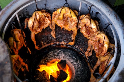 Grilled Chicken Hung in Ceramic Pot around Fire