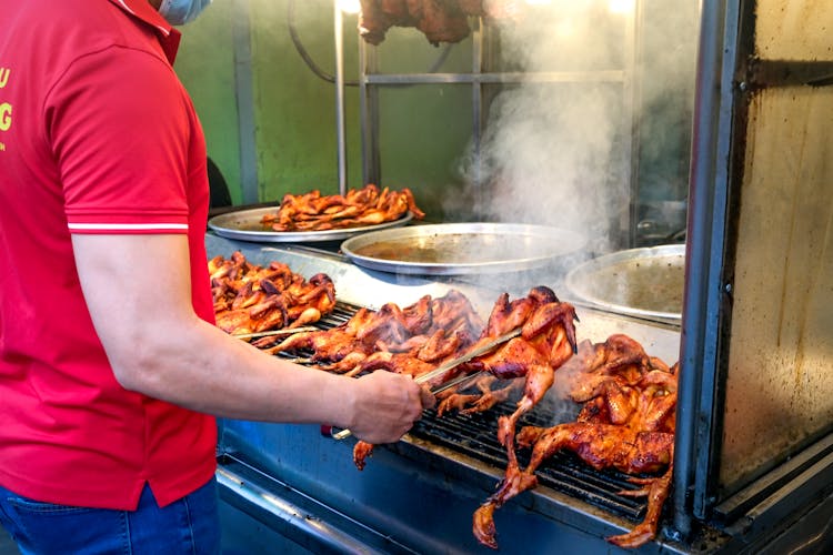 Man Cooking Chicken On Grill