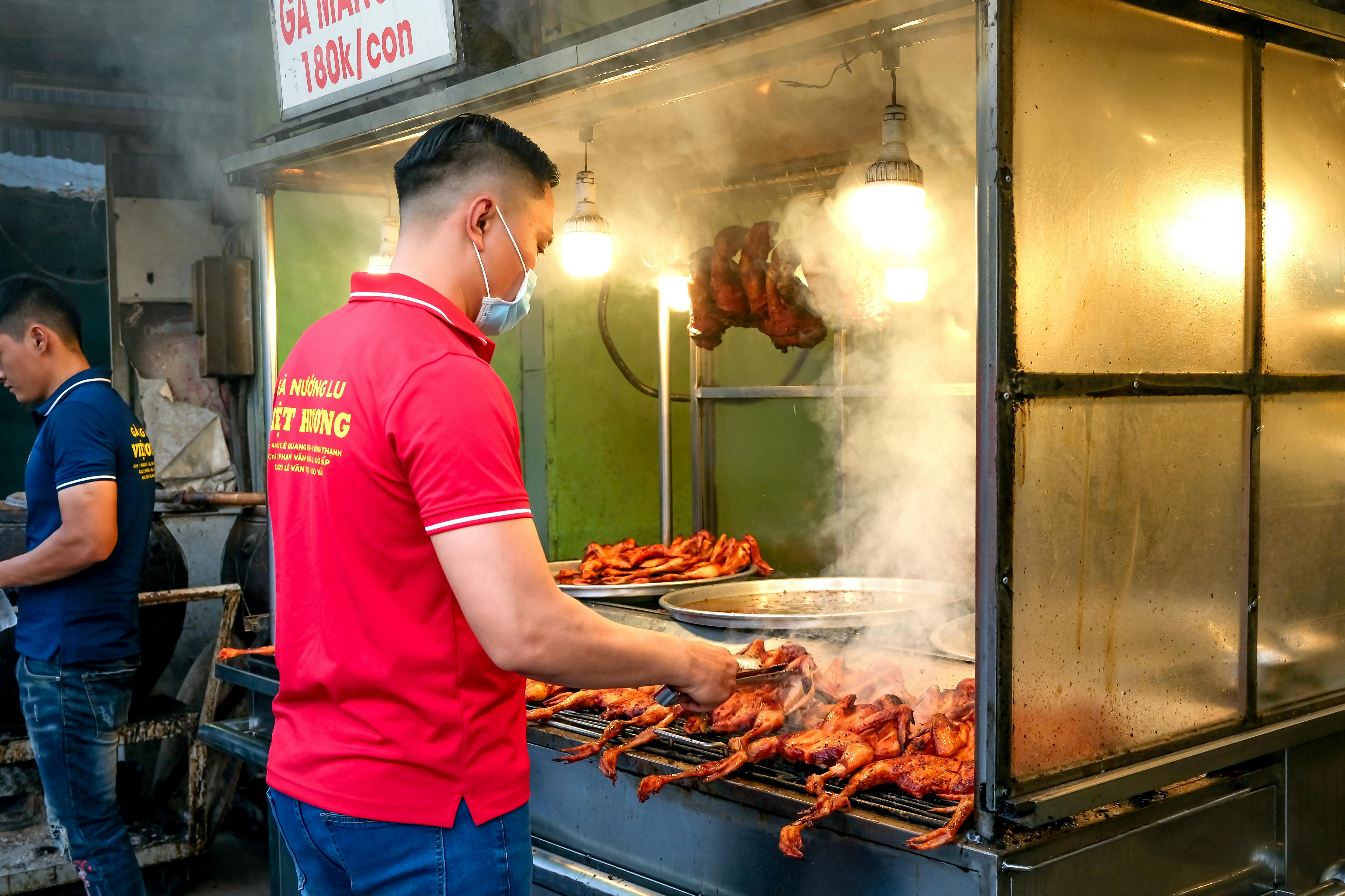 A Man in a Red Polo Shirt Grilling Chicken