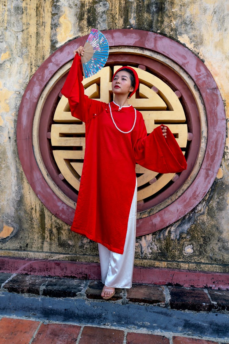 Woman In Traditional Clothing Holding A Fan 