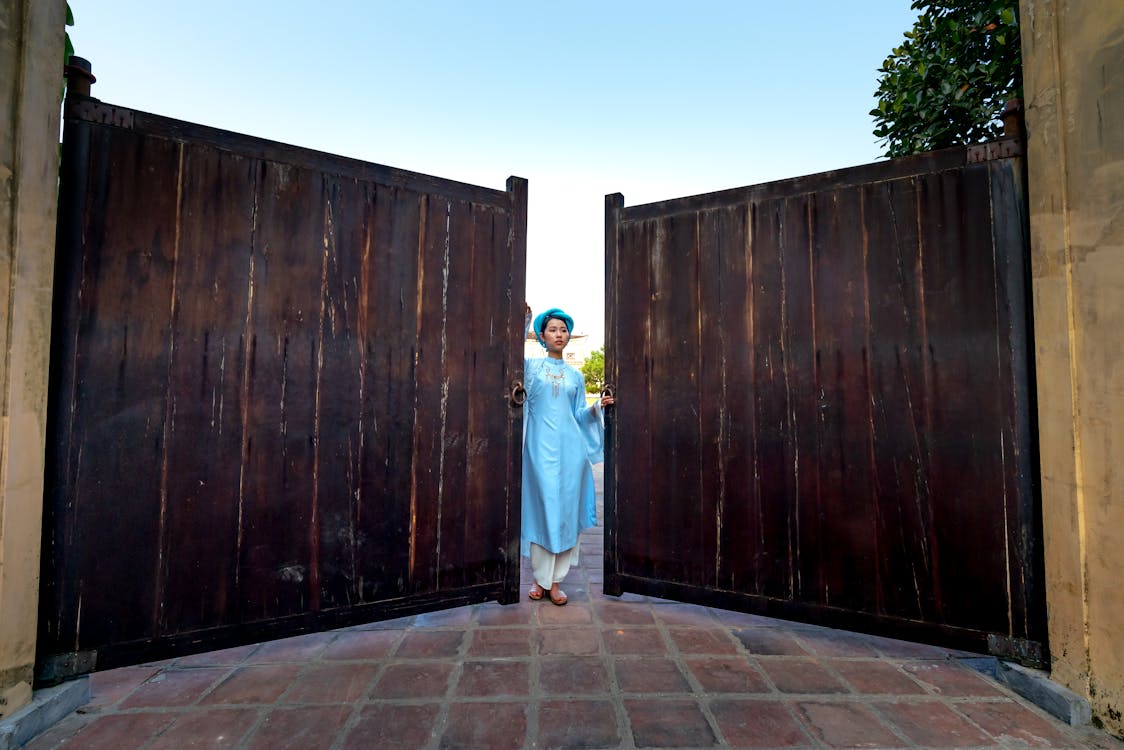 Woman Standing Beside Wooden Gate 
