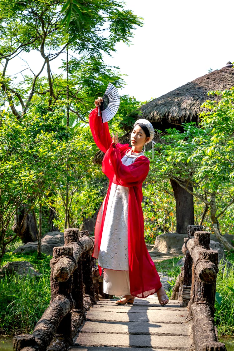 Young Woman Dancing And Holding Paper Fan