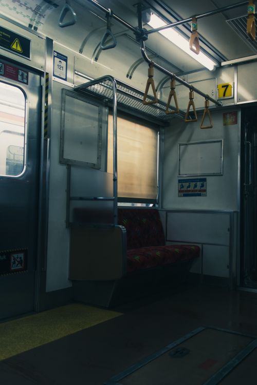 Free Dimly lit empty subway car with seats and handrails, urban setting. Stock Photo