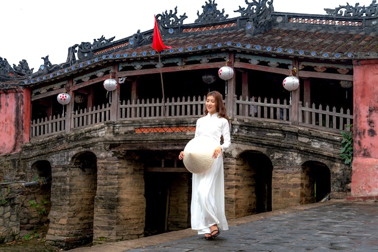 A Woman Wearing White Dress Near A Temple