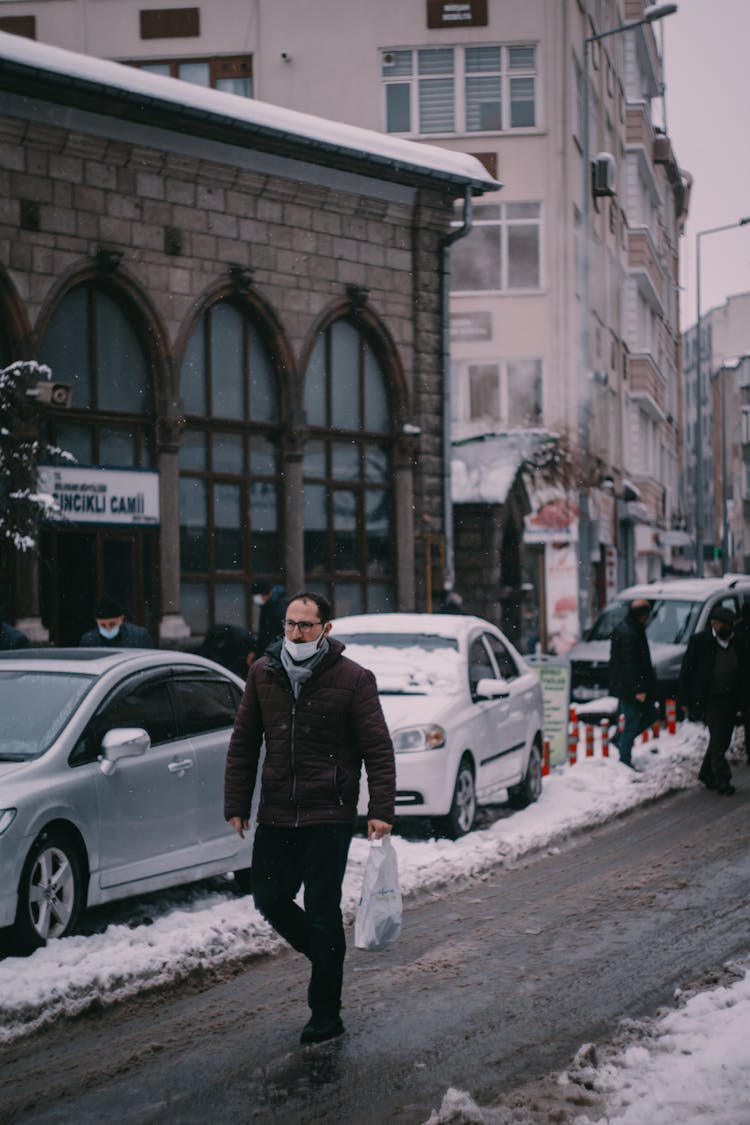 Man With A Shopping Bag Walking In The City In Winter 