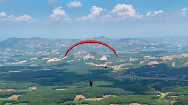 Person On Parachute Flying Above Fields