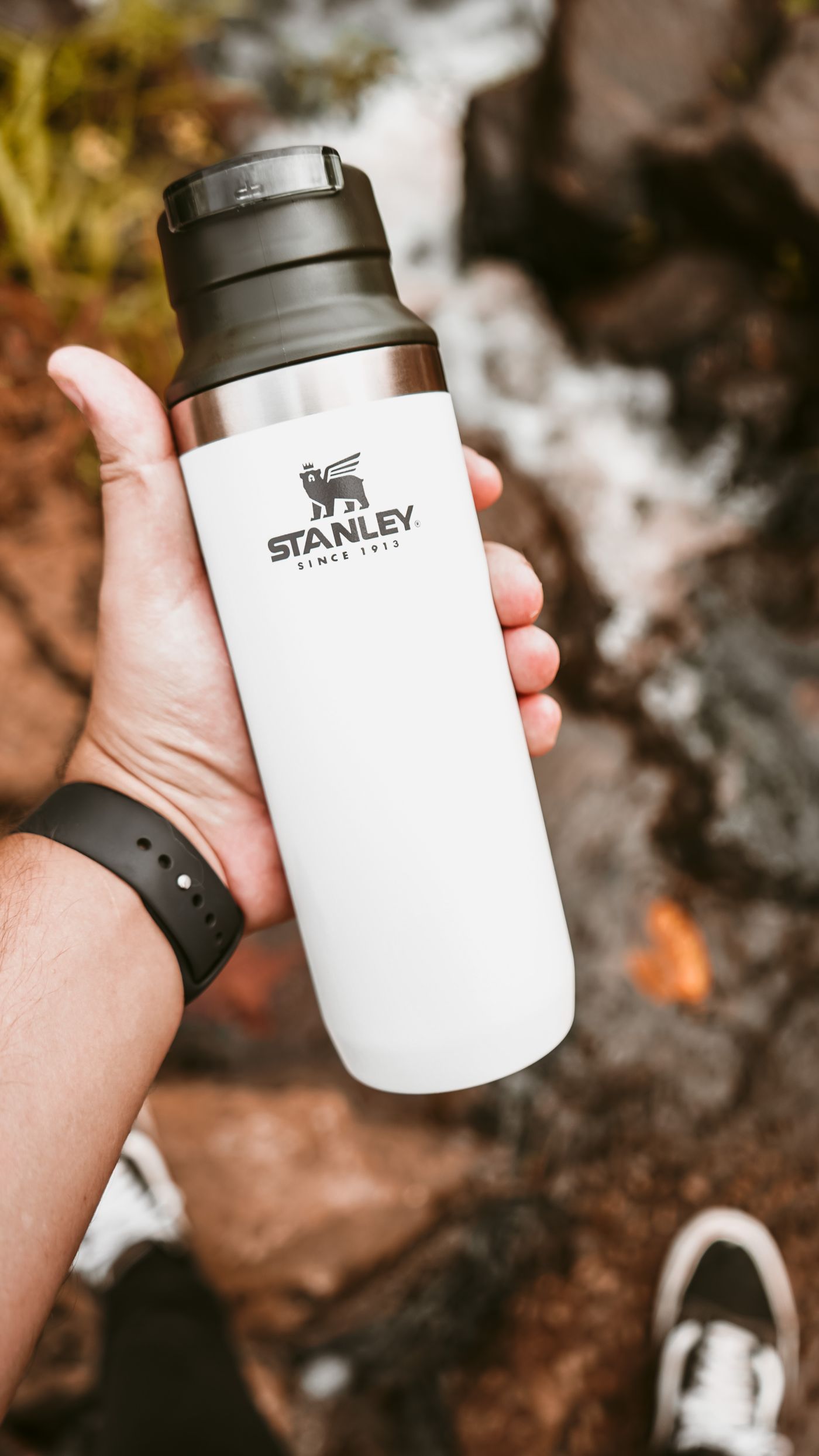Insulated bottle beside a stream