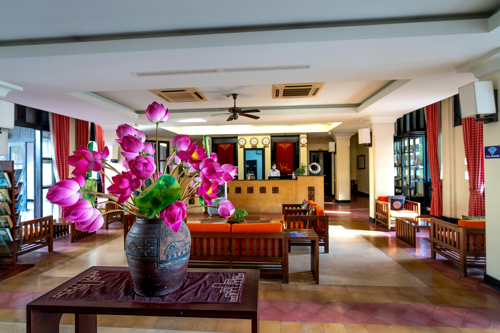 A beautifully decorated hotel lobby featuring a vibrant flower arrangement in a stylish vase.