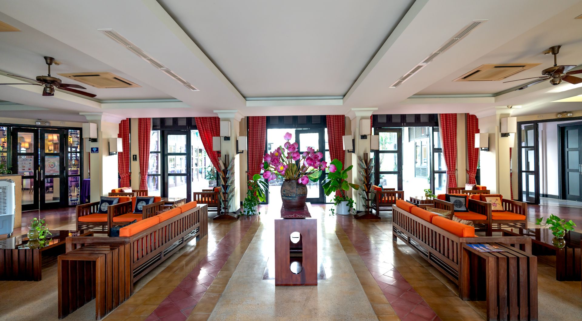 Luxurious hotel lobby showcasing elegant furniture and vibrant floral arrangements.