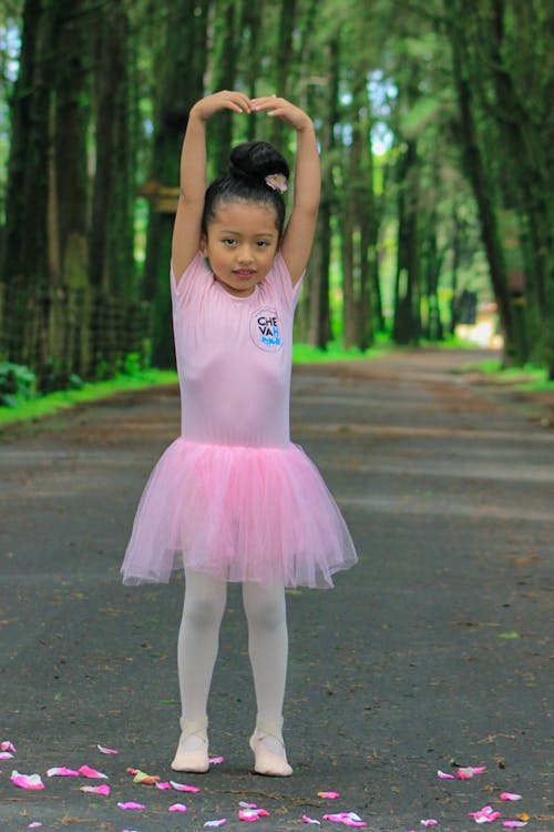 Cute adorable ballerina little girl in pink tutu dance practices