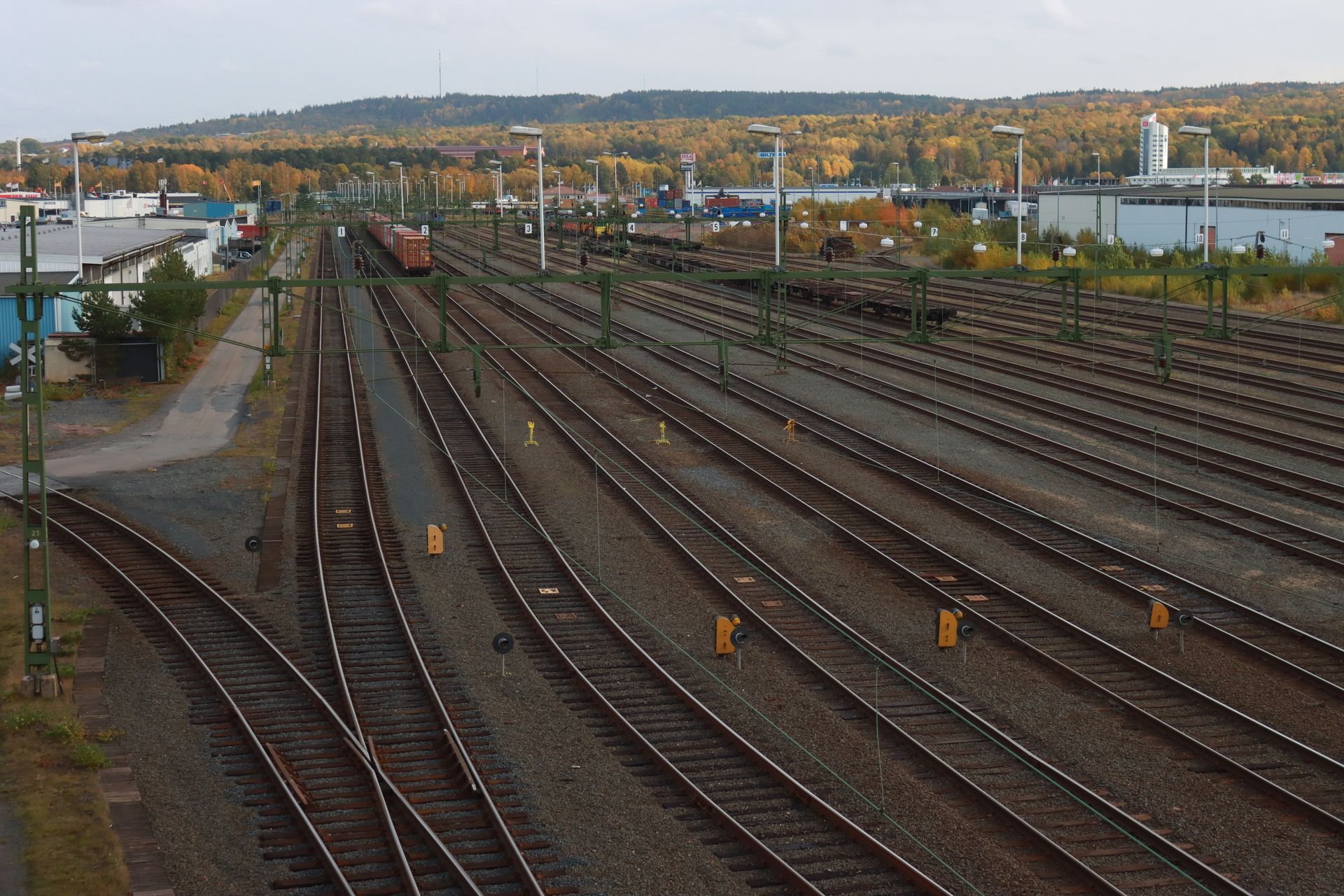 Aerial view of railway tracks in Jönköping, Sweden with autumn foliage, showcasing industrial transportation.