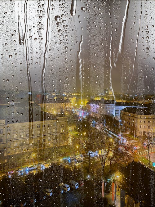Free Water Droplets on Glass Window Overlooking City Buildings Stock Photo