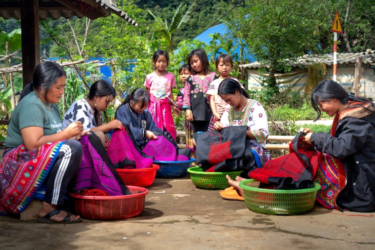 Women Sewing Fabric In Baskets