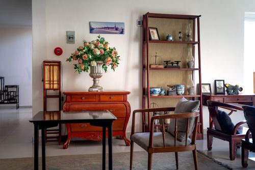 Free Classic living room interior featuring a floral bouquet, wooden furniture, and decorative ceramics. Stock Photo