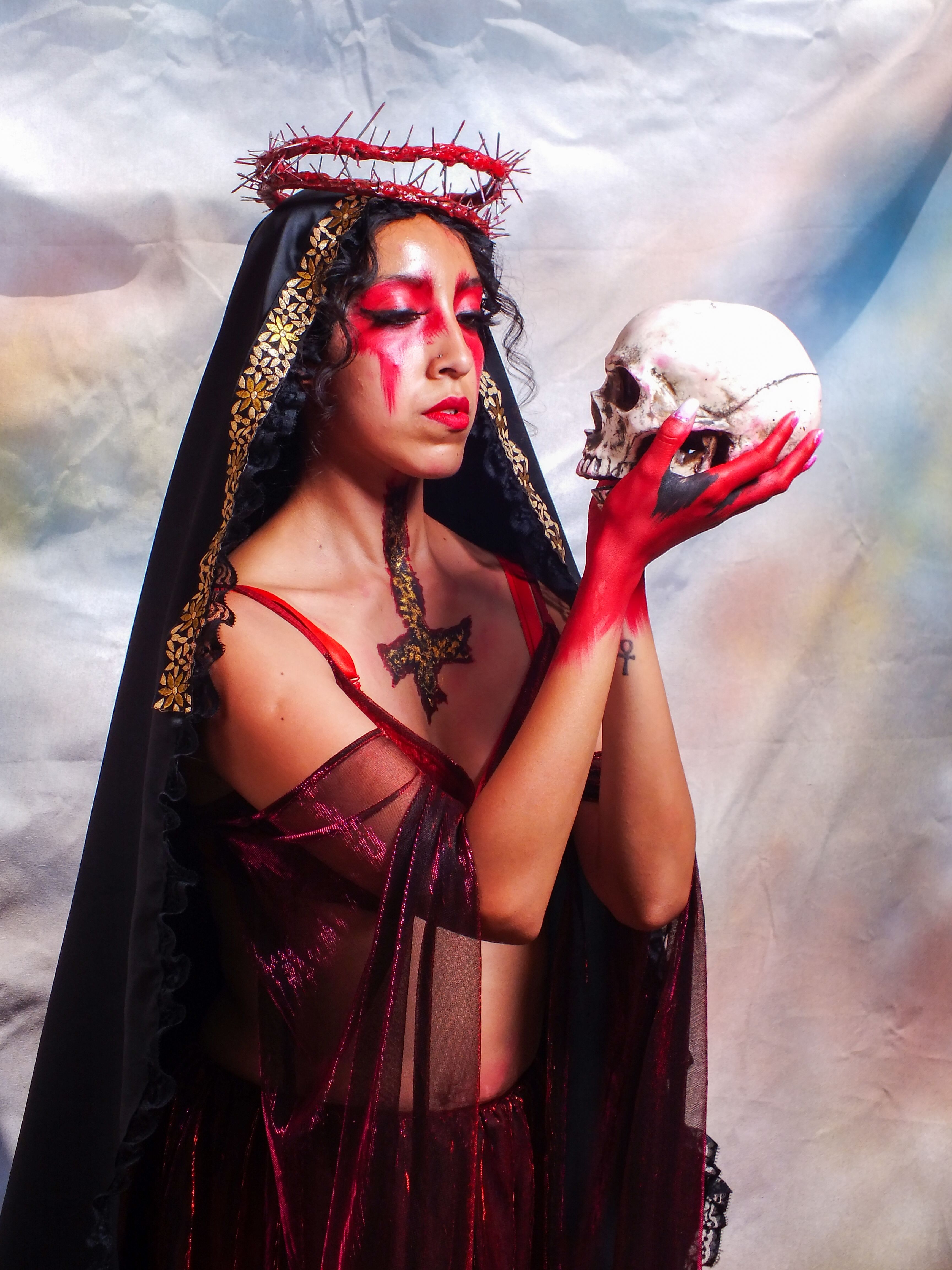 Artistic portrait of a woman in costume holding a skull, evoking mystery.