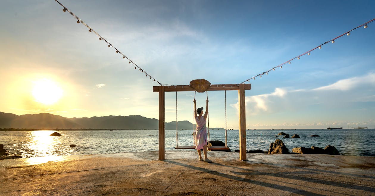 Woman Standing in Between Swing Chairs on the Beach