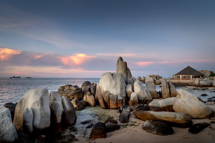 Rocks On The Shore In A White Sand Beach