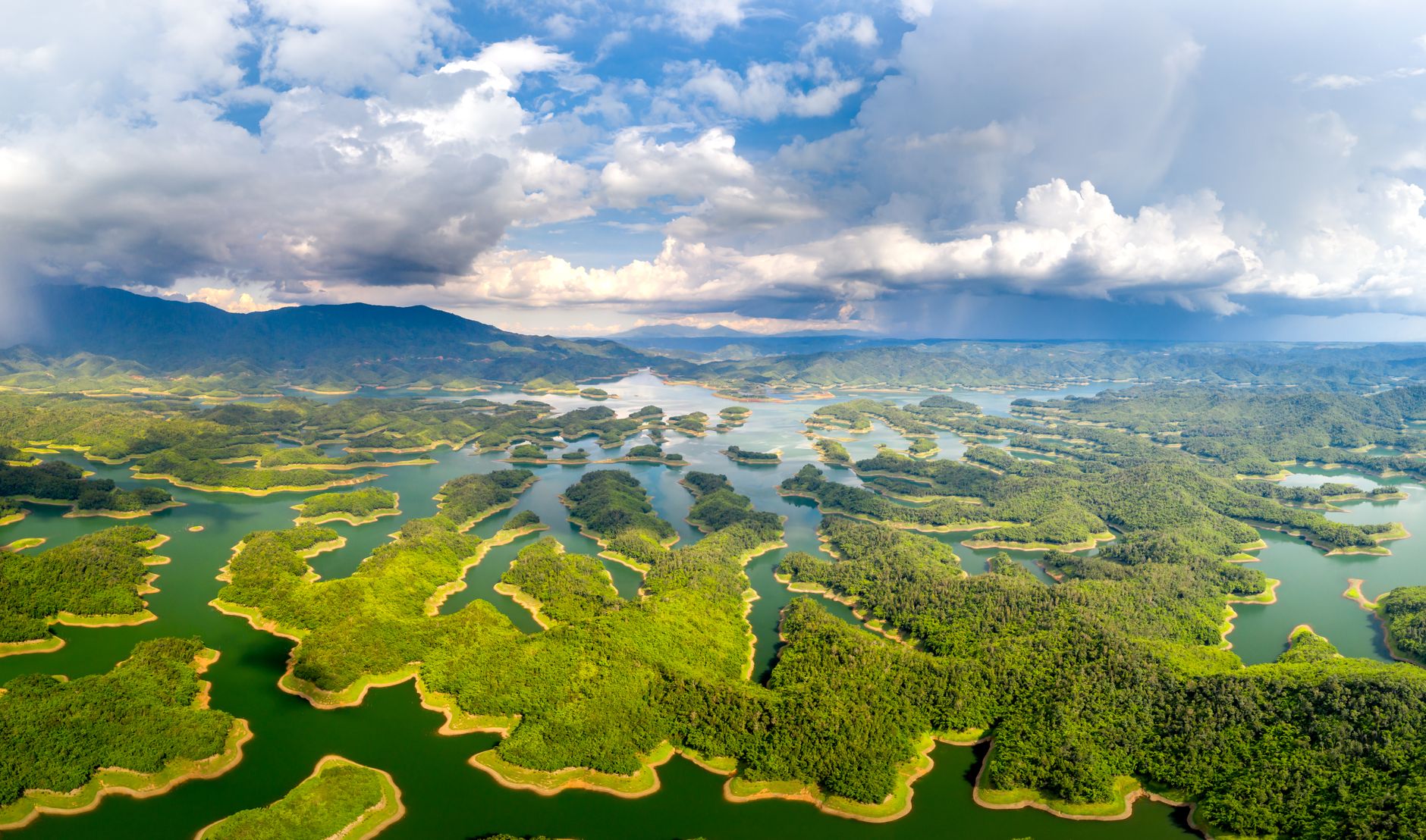 A breathtaking aerial view of a lush, green island archipelago amidst clear blue waters.