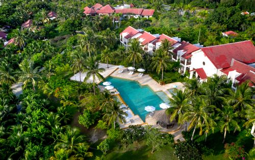 Free Stunning aerial shot of a resort with swimming pool and lush palm trees for a tropical getaway. Stock Photo