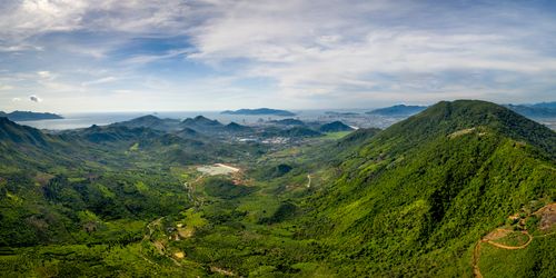 Free A breathtaking aerial panorama of verdant mountains and coastline under a clear blue sky. Stock Photo
