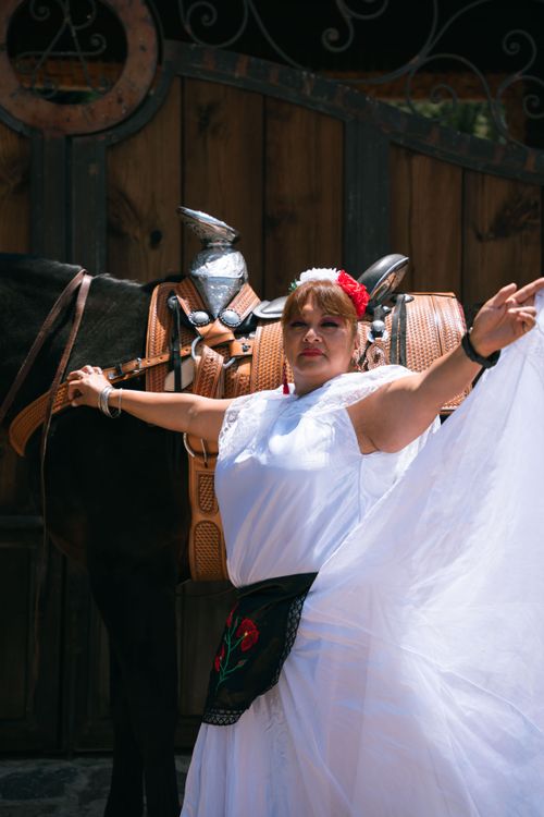 Free Woman in traditional Mexican dress posing with a horse outdoors, showcasing folklore fashion. Stock Photo