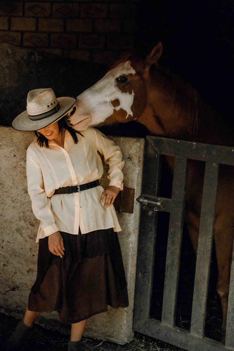 Woman In Cowboy Hat Near Horse At Farm