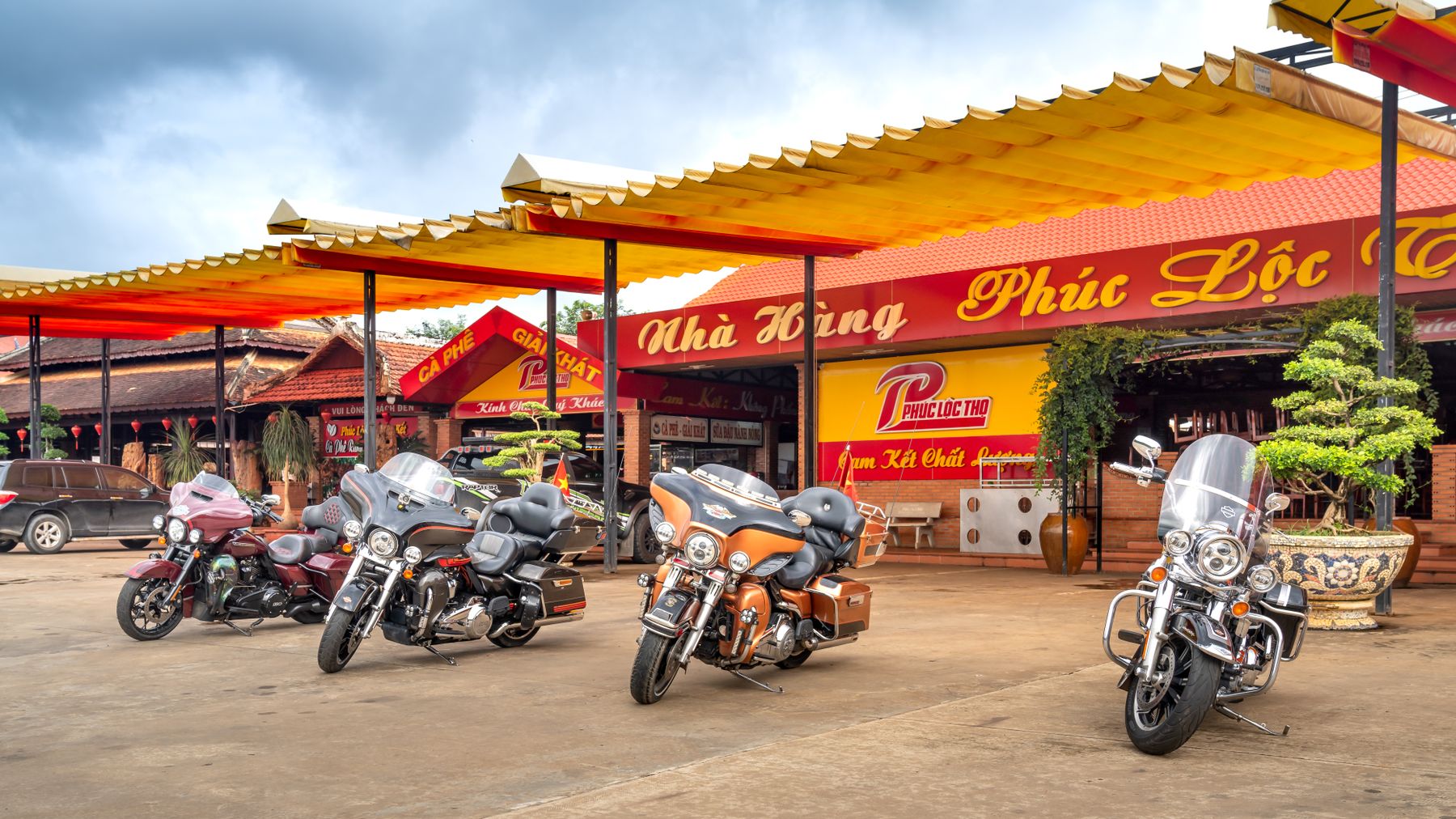 Colorful motorcycles parked outside a traditional Vietnamese restaurant.