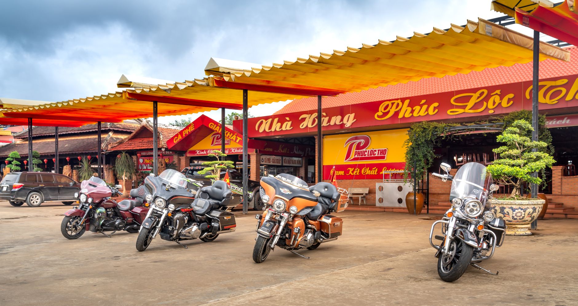 Colorful motorcycles parked outside a traditional Vietnamese restaurant.
