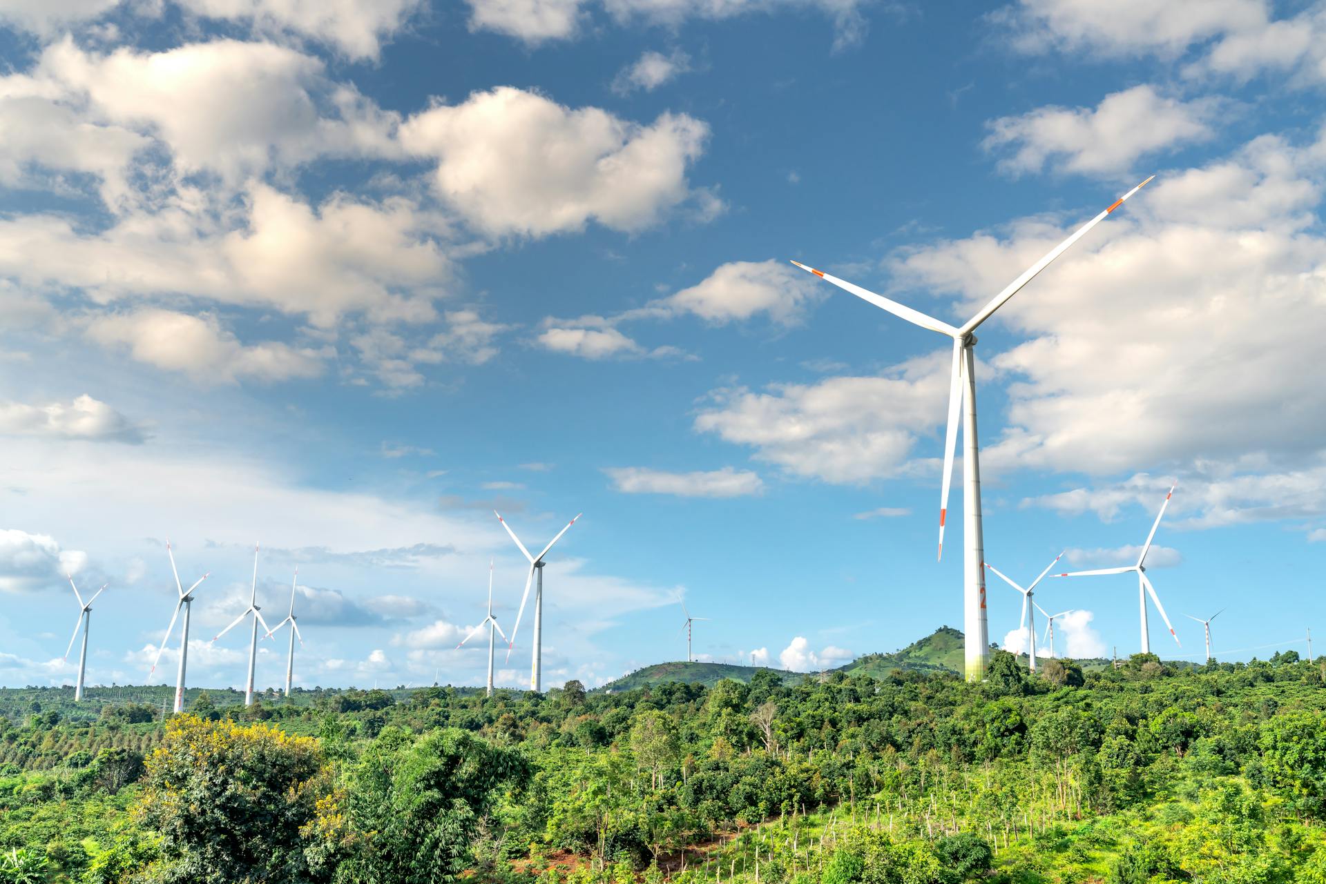 White Wind Turbines on Green Grass Field Under Blue Sky