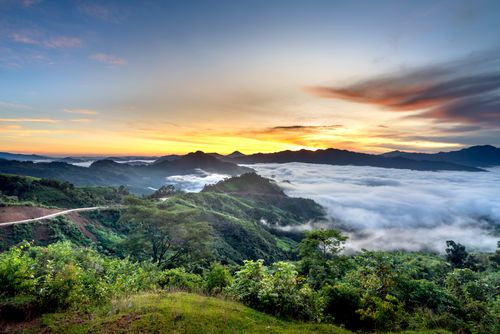 Free Serene sunrise over misty mountains and lush highlands, creating a dramatic scenic view. Stock Photo