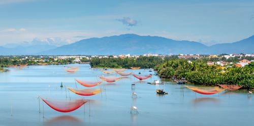 Free A beautiful aerial view showcasing colorful fishing nets on a serene river with a mountainous backdrop. Stock Photo
