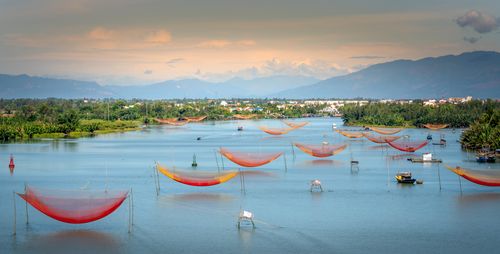 Free Colorful fishing nets over a serene river with mountains in the background. Stock Photo
