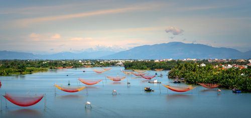 Free Stunning aerial view of colorful fishing nets on a tranquil river with lush greenery and distant mountains. Stock Photo