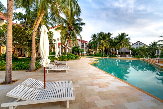 Explore a serene tropical resort with a pristine swimming pool, perfect for a summer vacation escape.