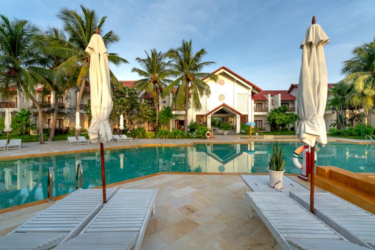 Swimming Pool Surrounded By Empty Deck Chairs