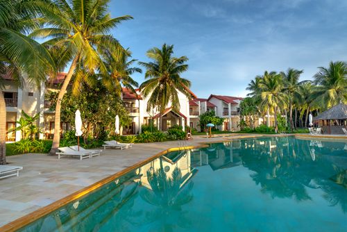 Free Luxury resort poolside view with palm trees, offering a tropical and serene escape. Stock Photo