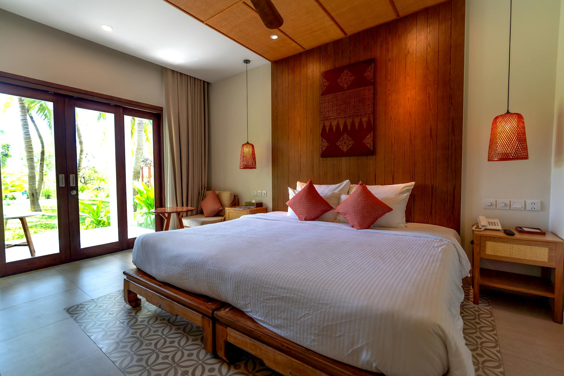 Contemporary hotel room with wooden accents and large windows offering a garden view.