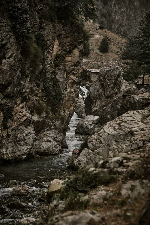 Free A captivating view of a rocky gorge with a flowing stream amidst natural beauty. Stock Photo