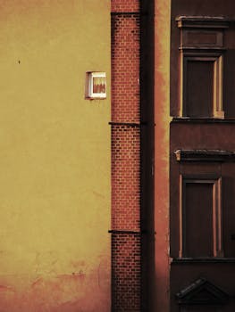A retro urban building facade featuring a small window and textured brickwork, perfect for urban design themes.