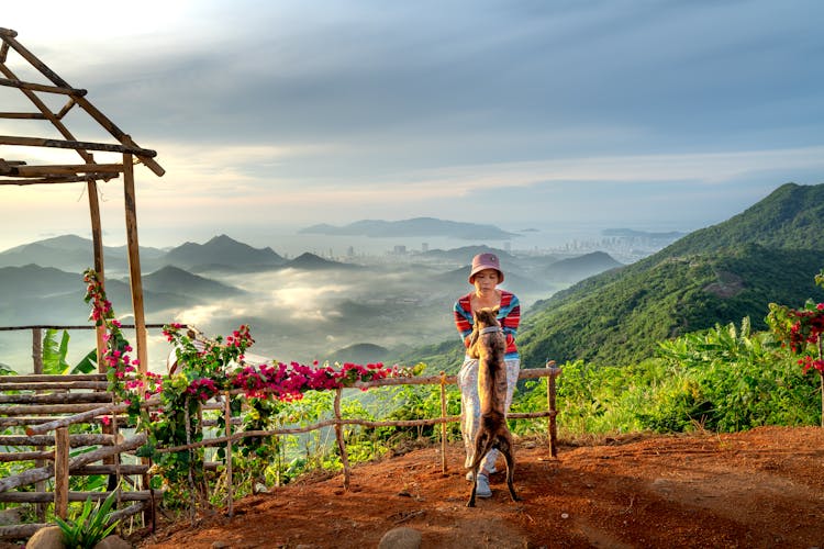 Woman And Dog On Mountain Viewpoint