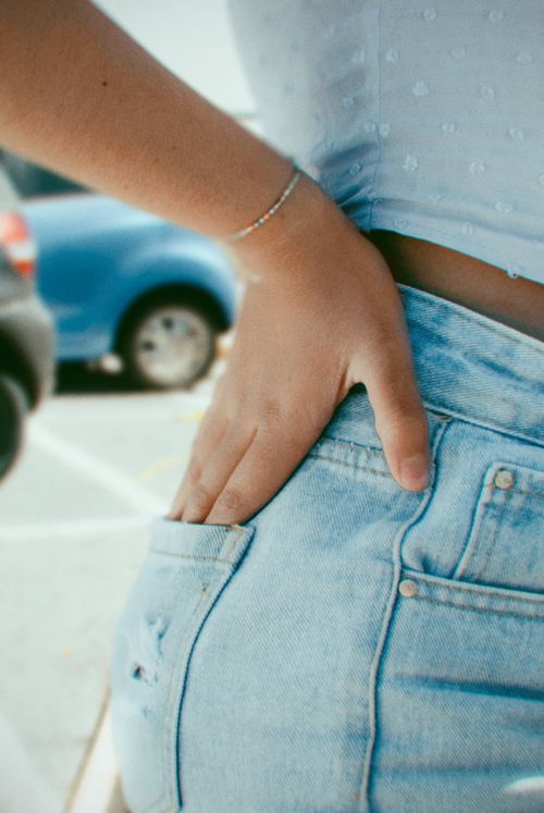 Free A close-up shot of a woman casually placing her hand in a back pocket of jeans. Stock Photo