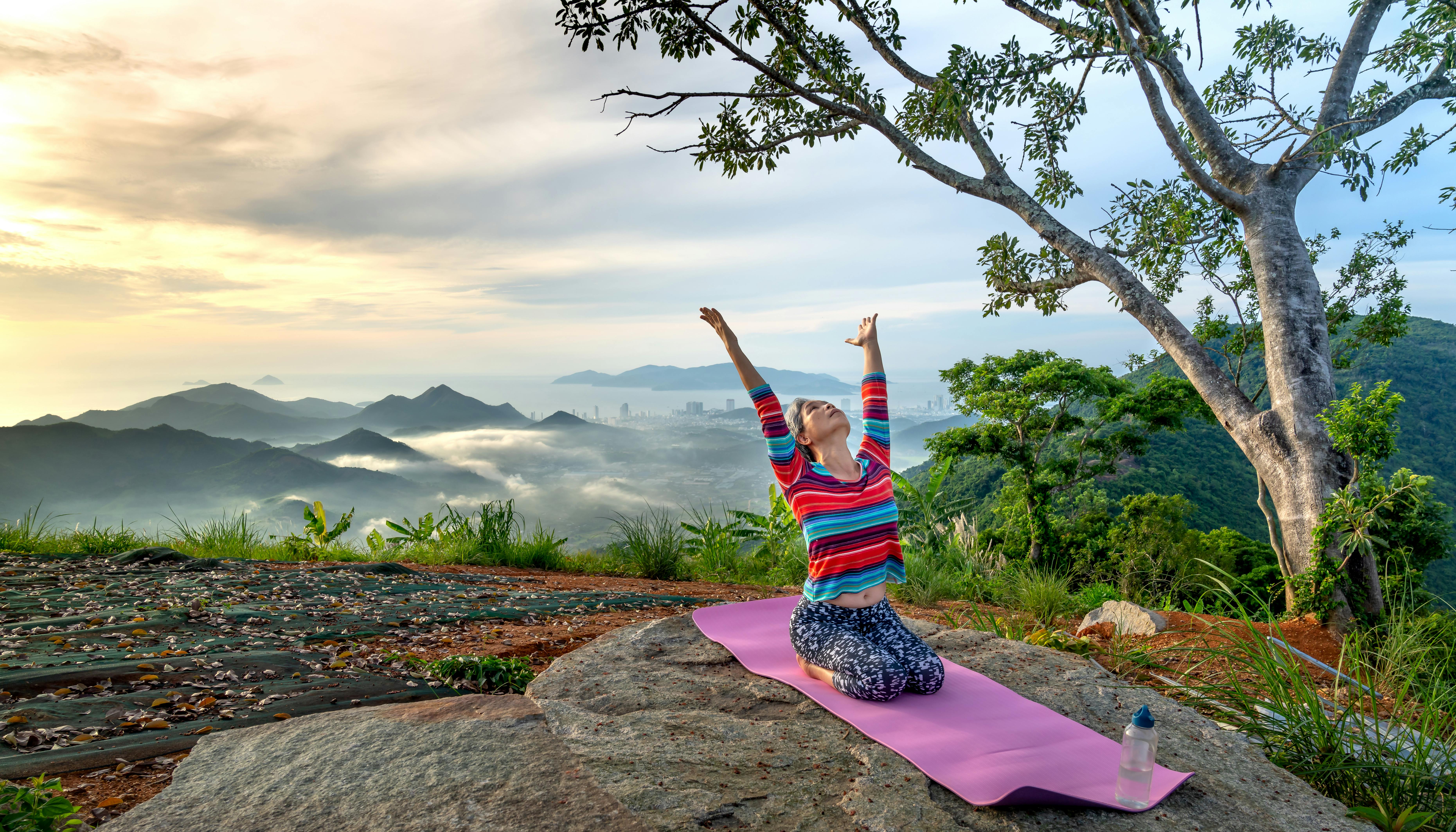 Free Woman Kneeling on a Yoga Mat with Her Arms Raised how to start meditate