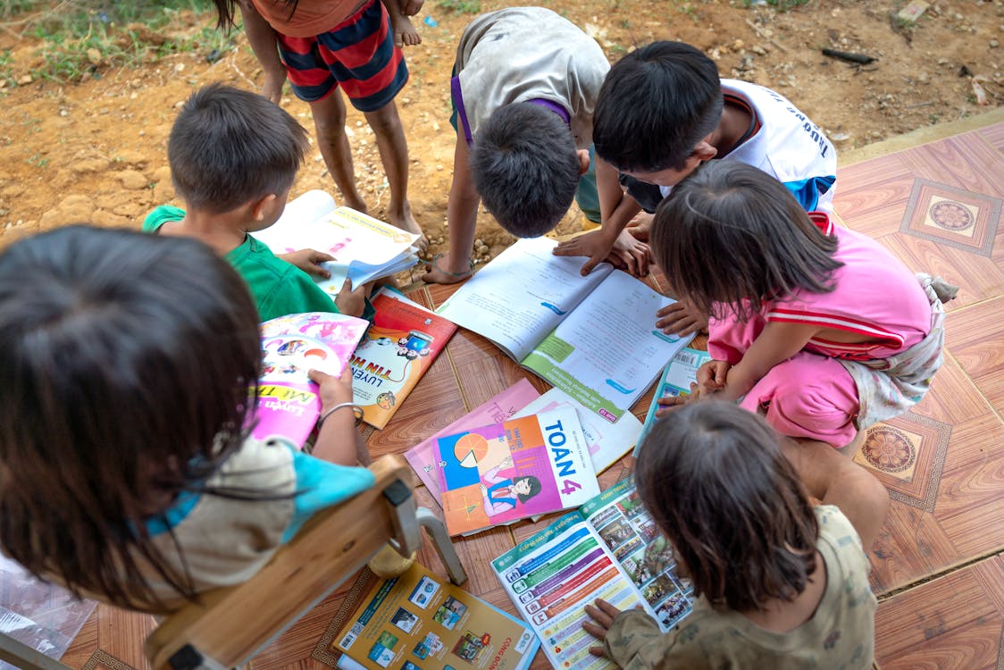 A group of children reading books together, engaging in a collaborative and educational activity.