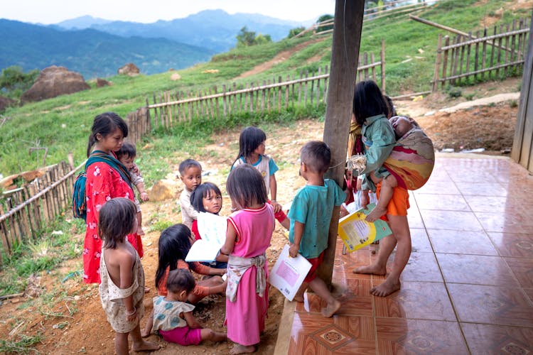 Group Of Children Having Conversation On Porch Of A House