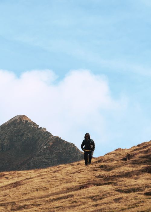 Free A solitary man hiking on a scenic hillside in Shkodër, Albania, under a bright blue sky. Stock Photo