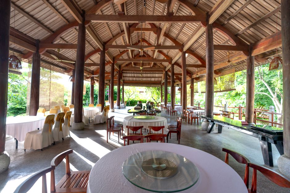 Interior of Stream Restaurant by Atelier Guo, showcasing exposed wooden beams, natural light, and a harmonious blend of contemporary design with natural materials.
